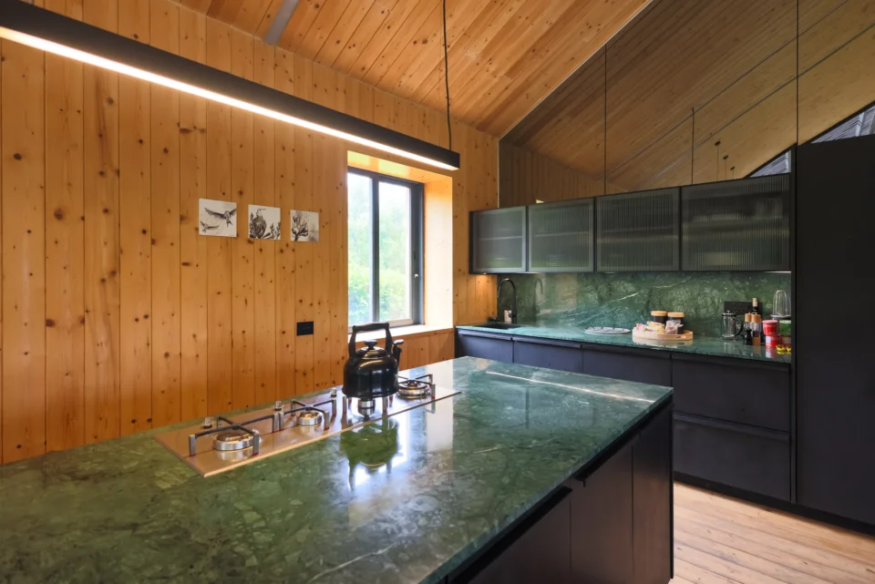 Apple Grove: kitchen with a green-stone island, gas hob and black cabinets against pine walls, Old Mac Daddy, Elgin Valley