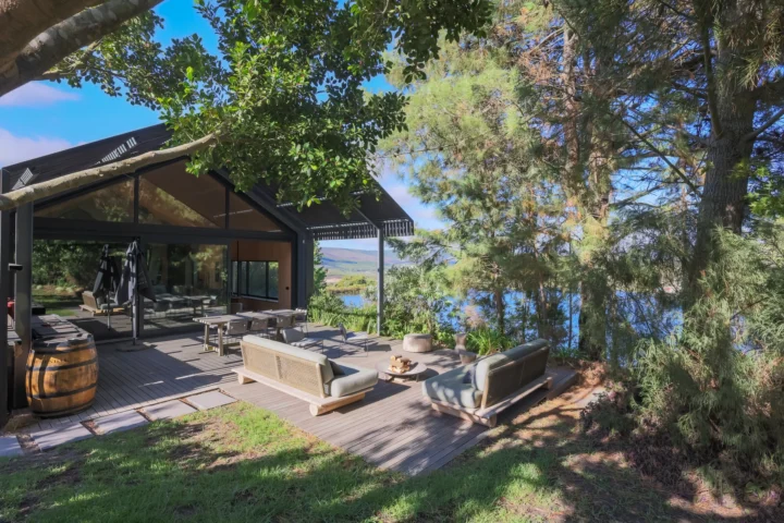 Home Apple Grove: the lodge from the lawn, with outdoor sofas and a wine barrel on the deck among the trees, Old Mac Daddy, Elgin Valley