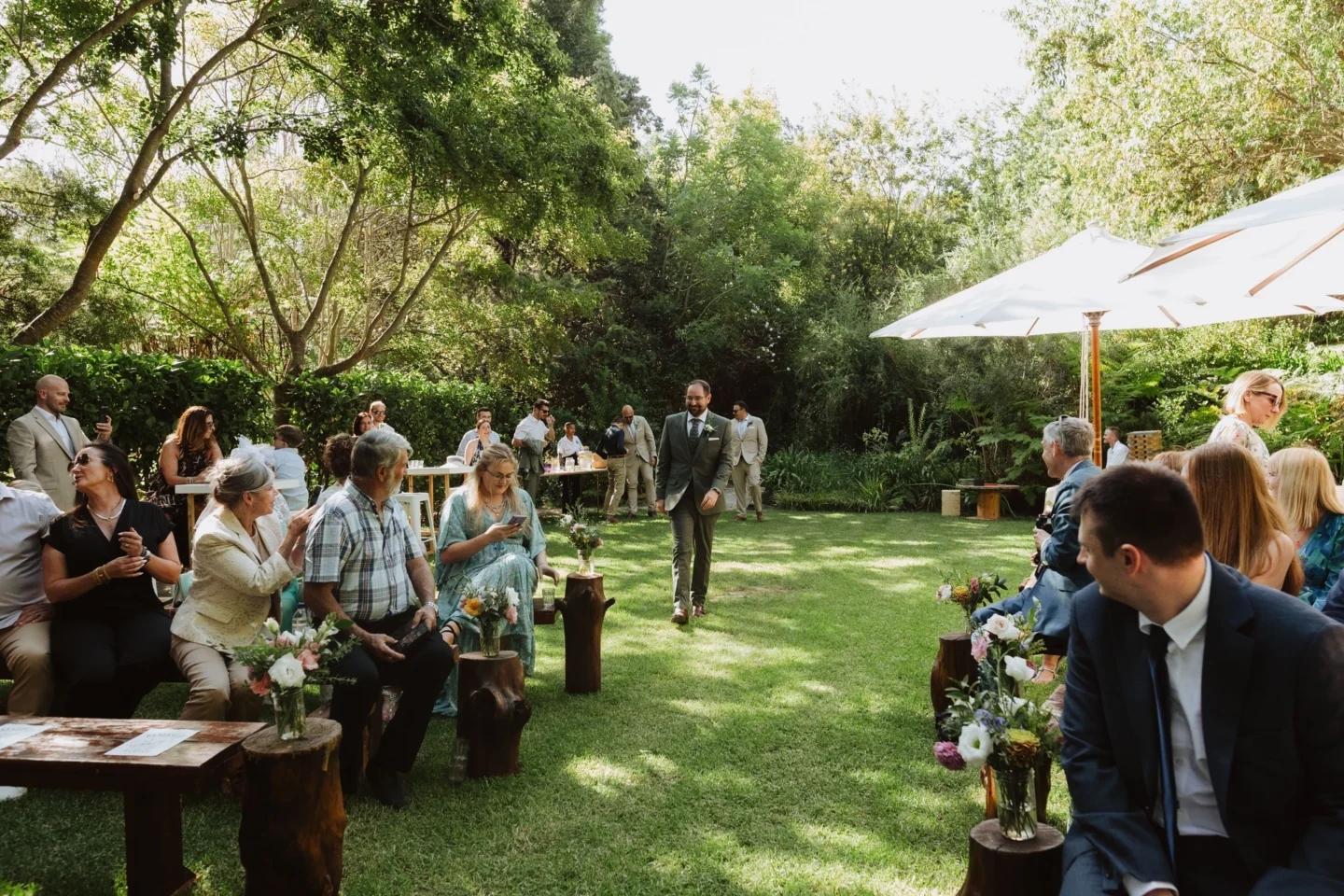 Wedding guests seated on the ceremony lawn under white umbrellas and tall trees, Old Mac Daddy, Elgin Valley