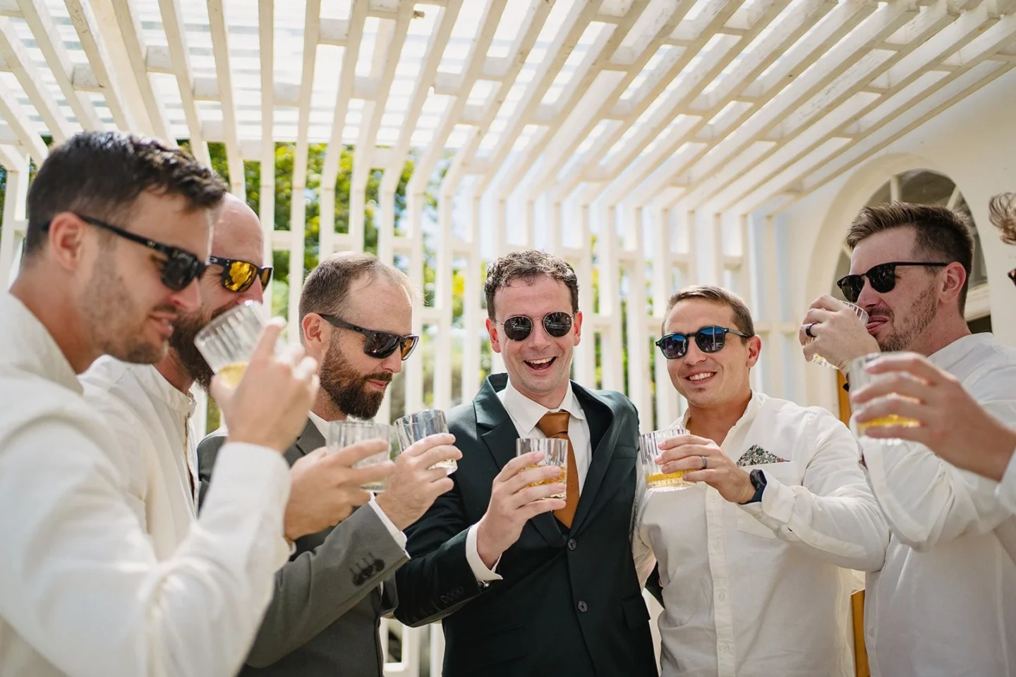 Groomsmen in sunglasses raising a toast under a white pergola, Old Mac Daddy, Elgin Valley