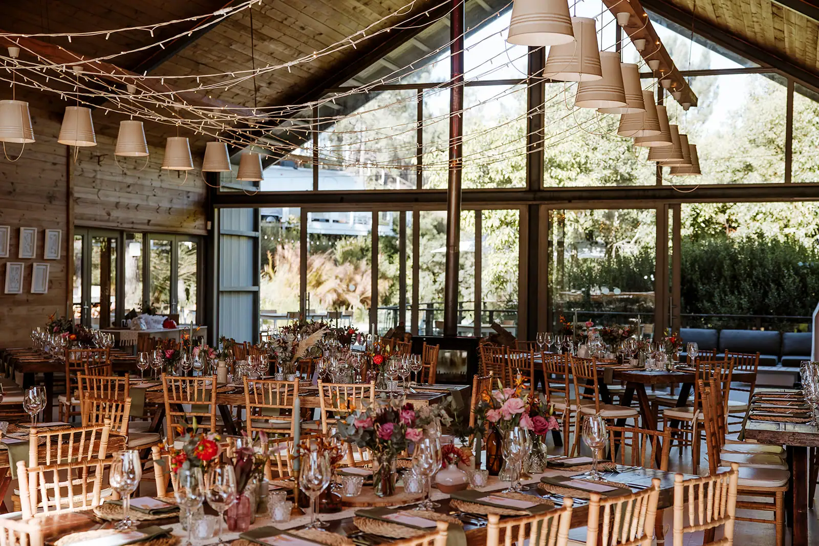 Weddings & Events (new) The Barn set for a wedding reception: long tables with flowers and candles under a canopy of fairy lights, Old Mac Daddy, Elgin Valley