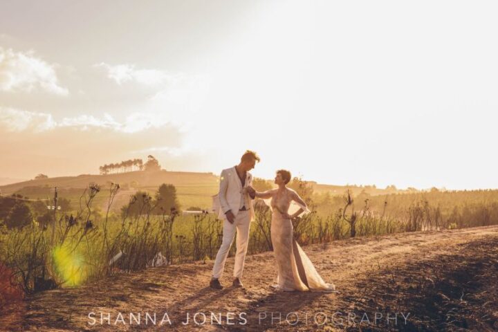 A bride and groom on a dirt track at golden hour, with the hills behind, Old Mac Daddy, Elgin Valley