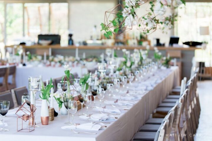 Long reception tables set with glassware, candles and greenery, Old Mac Daddy, Elgin Valley